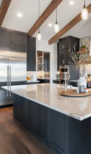 Sydney kitchen renovation with stone island – WizBuilt modern Sydney kitchen renovation with dark cabinetry, stone island bench and timber ceiling beams